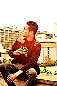 Portrait of man sitting on roof