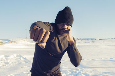 Man standing on beach against sky during winter