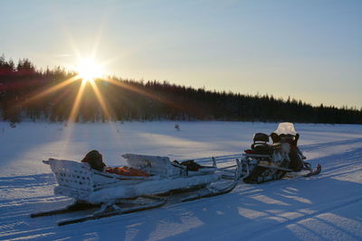 Scenic view of snow covered field against sky during sunset