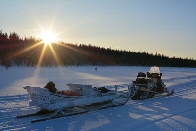 Scenic view of snow covered field against sky during sunset