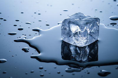 Ice cube and water in back lit close-up