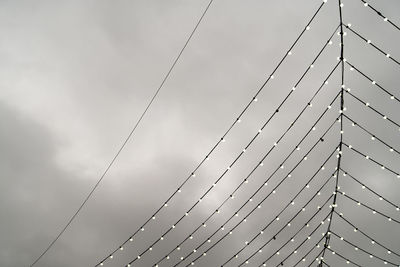 Low angle view of illuminated lights against cloudy sky