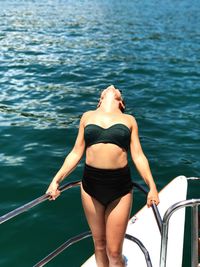 Woman standing on boat in sea during sunny day