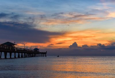 Silhouette pier over sea against sky during sunset