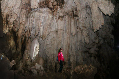 Woman standing on rock in cave