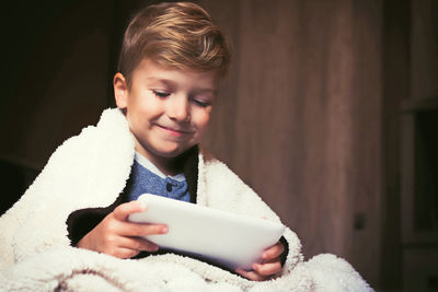 Portrait of happy boy holding mobile phone