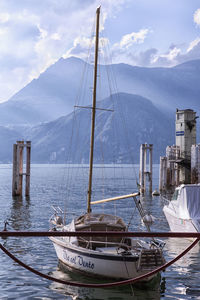 Sailboats moored in sea against sky