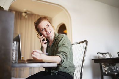 Woman at home talking via cell phone