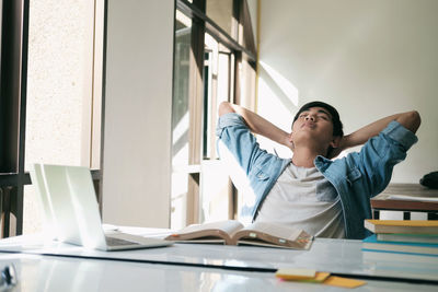 Male student sleeping by table