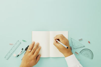 Midsection of person holding paper against white background