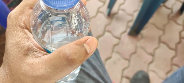 Close-up of hand holding glass bottle