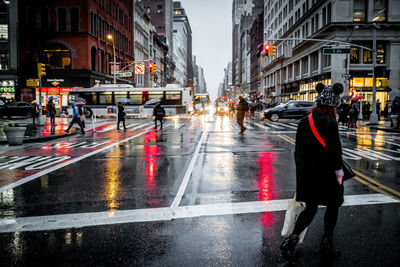 People walking on wet road during rainy season