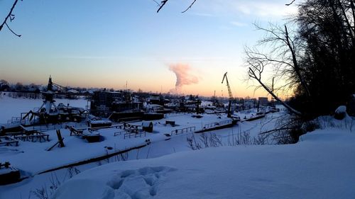 Snow covered houses against sky during winter