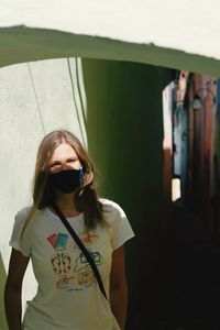 Portrait of a teenage girl wearing coronavirus mask standing outdoors