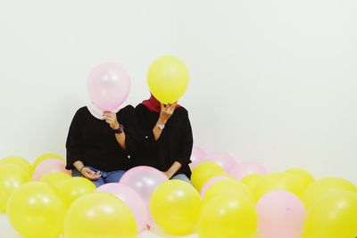 Multi colored balloons against white background