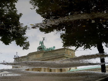 Built structure by trees against sky