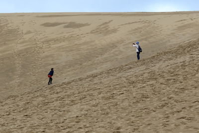 Full length of man walking on sand dune