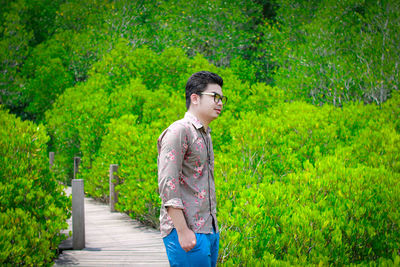 Man standing on grass against trees