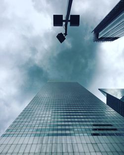 Low angle view of modern building against cloudy sky