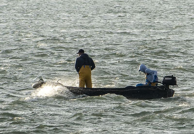 Rear view of men fishing in sea