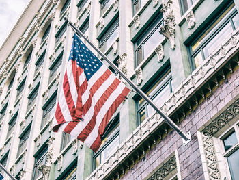 Low angle view of flag amidst buildings in city