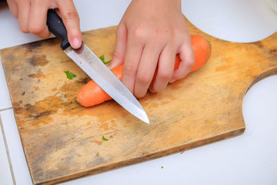 Midsection of woman preparing food on cutting board