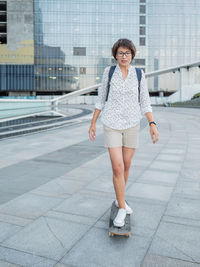 Full length of young woman standing on street