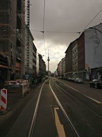 Cars on street in city against sky