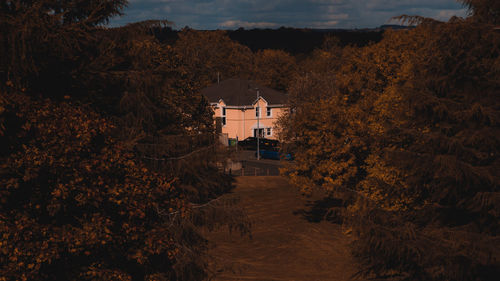 High angle view of trees by building against sky