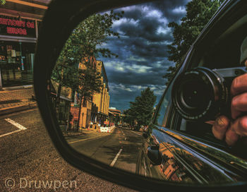 Reflection of sky on side-view mirror of car