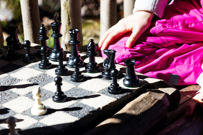 Midsection of woman playing with chess against blurred background