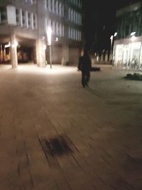 People walking on illuminated street at night