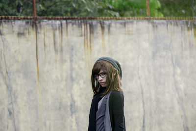 Young woman looking down while standing outdoors