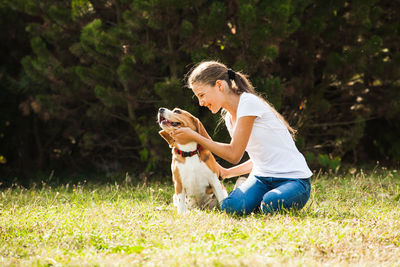 Girl playing with dog on grass