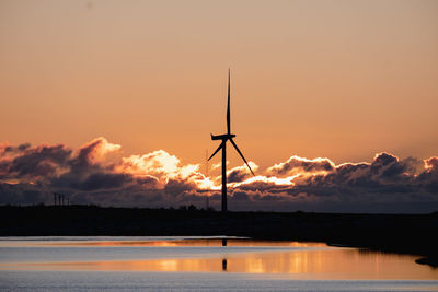 Scenic view of wind turbine during sunset