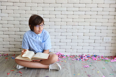 Boy sitting against wall