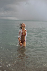 Woman wearing bikini walking in sea