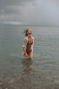 Full length of boy looking at sea against sky