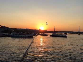 View of suspension bridge over sea during sunset