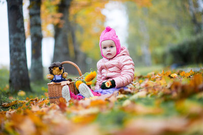 Cute baby girl sitting on field at park