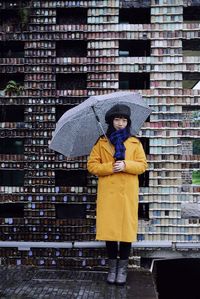 Portrait of woman standing with umbrella in rain