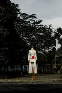 Rear view of woman standing on field against sky