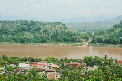 Scenic view of river by trees against sky