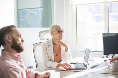 Woman working with colleague in board room