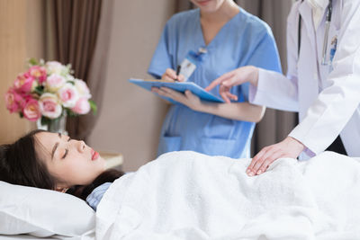 Midsection of doctor examining patient at clinic