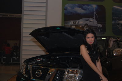 Portrait of woman standing by car