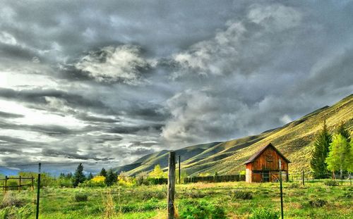 Scenic view of grassy field against cloudy sky