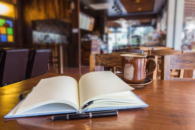 Close-up of open book on table in restaurant