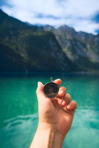 Cropped hand of person holding navigational compass