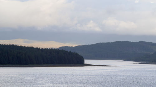 Scenic view of sea and mountains against sky